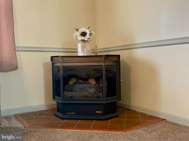 room details featuring carpet floors, a tiled fireplace, and baseboards