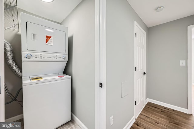 laundry area featuring hardwood / wood-style floors and stacked washer and dryer