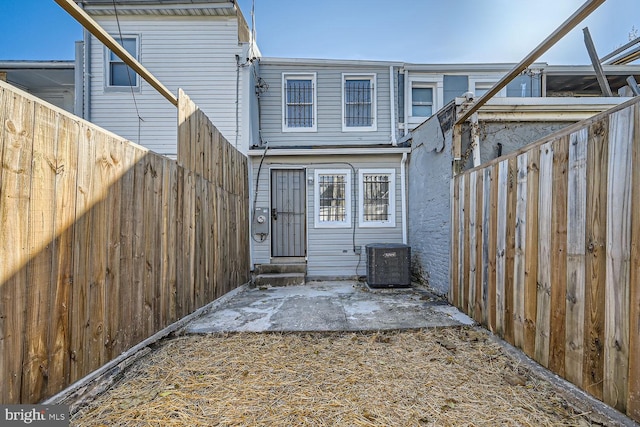 back of property featuring central air condition unit and a patio