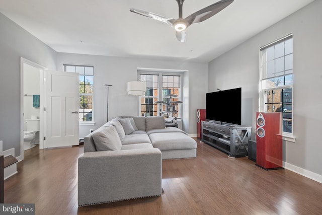 living room featuring ceiling fan and dark hardwood / wood-style floors