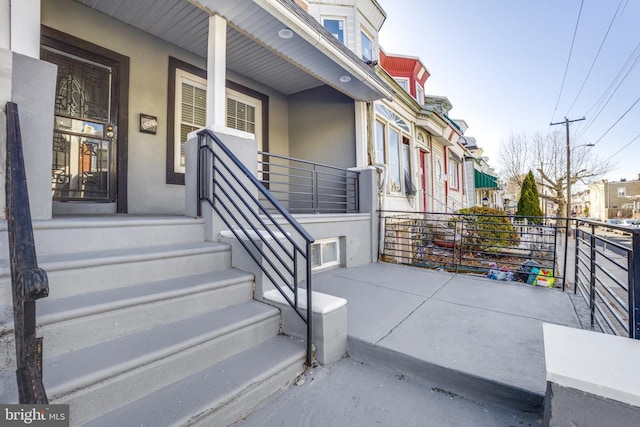 doorway to property featuring a porch and stucco siding