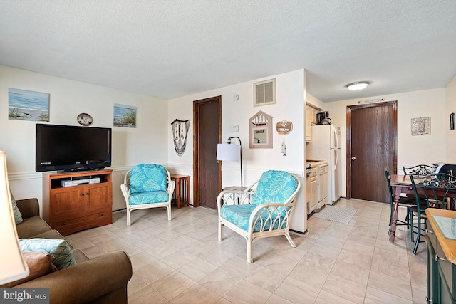 20 Amber St Unit E3, Beach Haven, NJ 08008 - living room featuring a textured ceiling and wainscoting