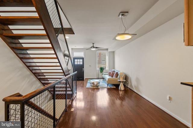 stairs with hardwood / wood-style flooring and ceiling fan