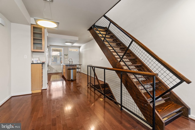 stairway with sink and wood-type flooring