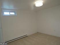 basement with baseboard heating and carpet floors