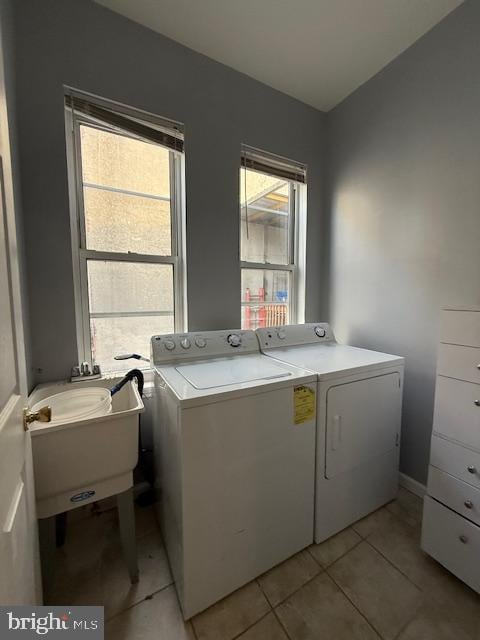 laundry room featuring washing machine and dryer, sink, and light tile patterned floors