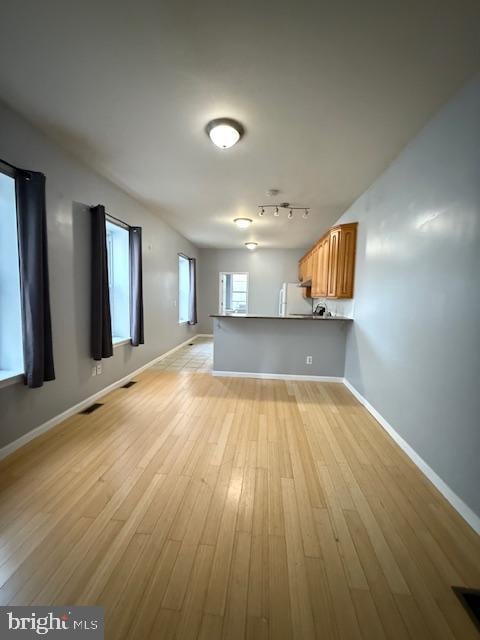 interior space with light hardwood / wood-style floors and track lighting