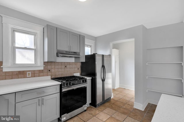 kitchen featuring tasteful backsplash, gray cabinets, and appliances with stainless steel finishes