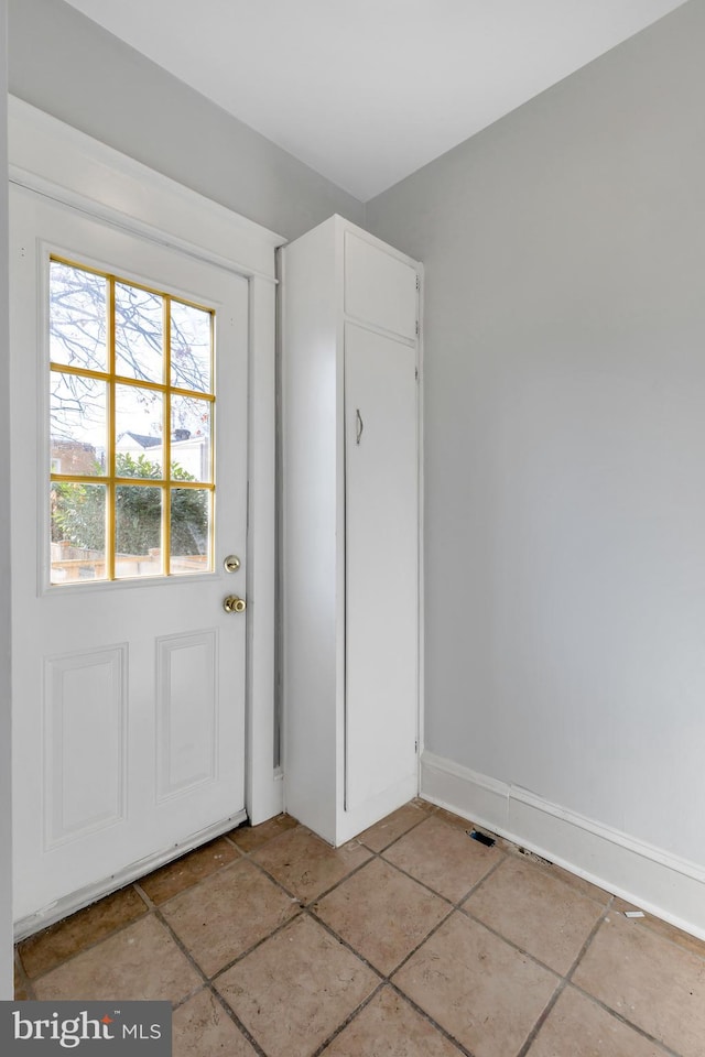 doorway to outside with light tile patterned floors