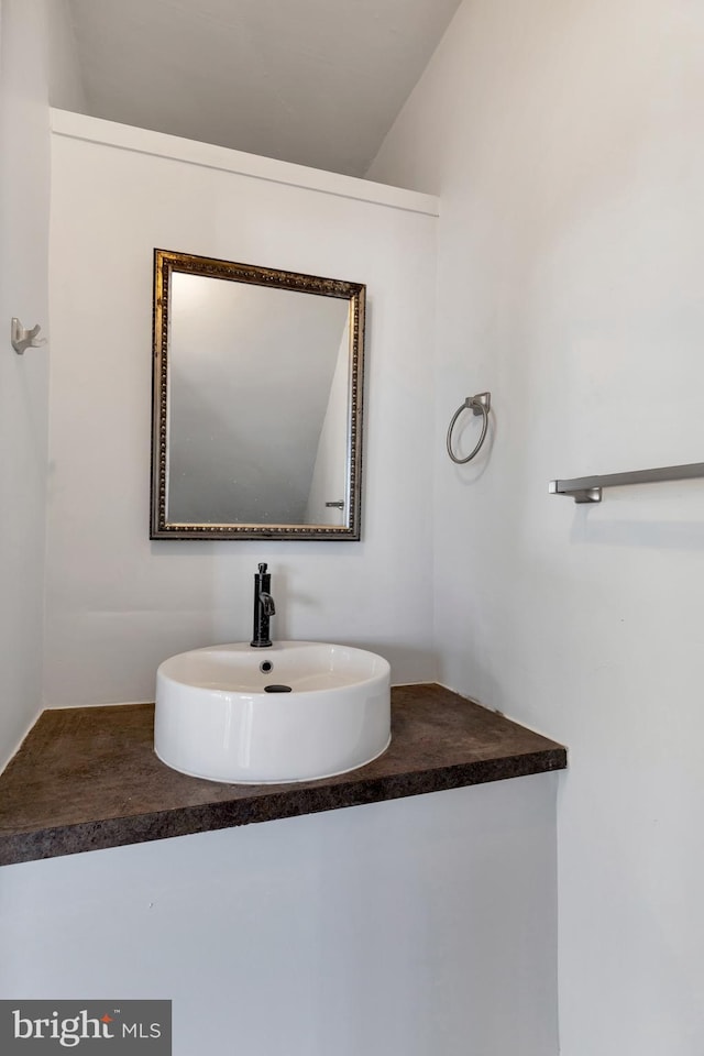 bathroom featuring sink and vaulted ceiling