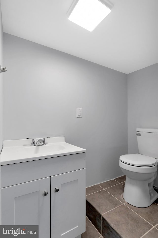 bathroom featuring toilet, vanity, and tile patterned floors