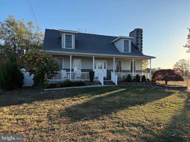 view of front facade featuring covered porch and a yard