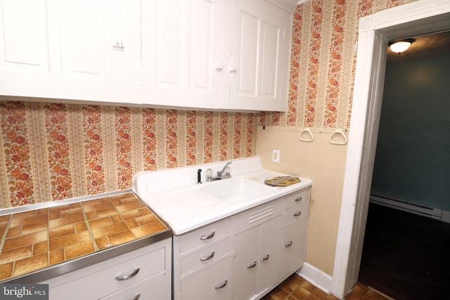 interior space featuring white cabinetry and sink