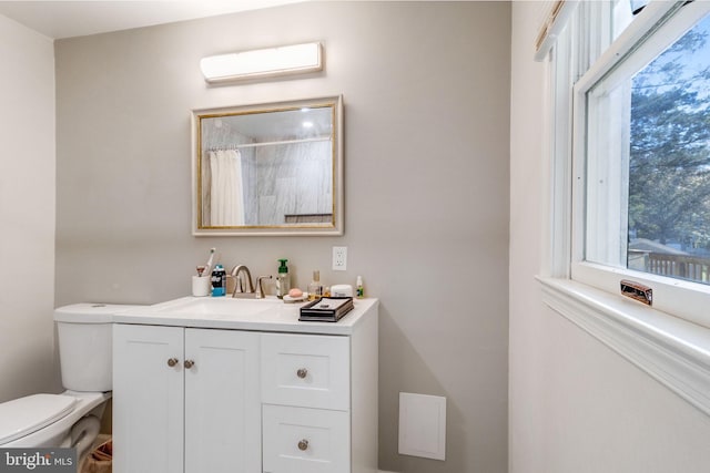 bathroom featuring vanity, an AC wall unit, and toilet