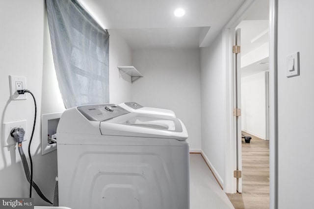 washroom with independent washer and dryer and light hardwood / wood-style flooring