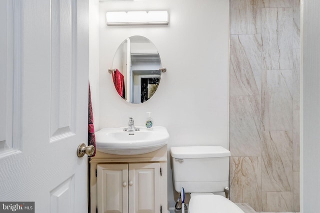 bathroom with a wall unit AC, vanity, and toilet