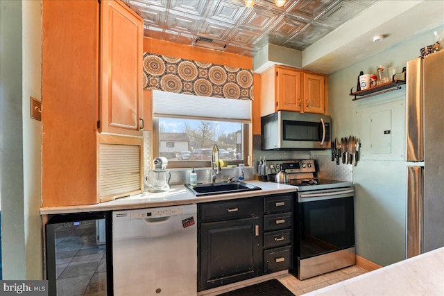 kitchen featuring an ornate ceiling, a sink, light countertops, wine cooler, and appliances with stainless steel finishes