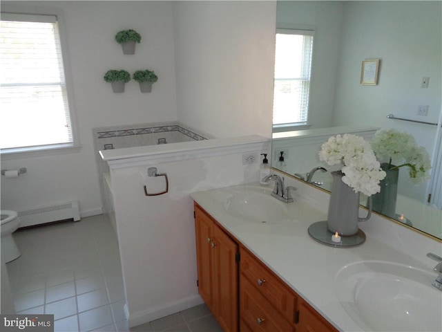 bathroom featuring vanity, tile patterned flooring, baseboard heating, and plenty of natural light