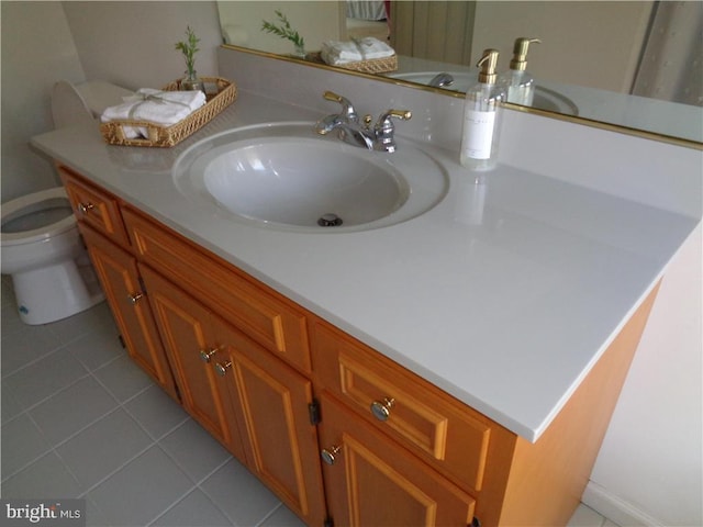 bathroom with tile patterned flooring, vanity, and toilet