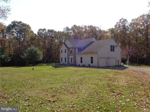 rear view of house with a lawn and a garage