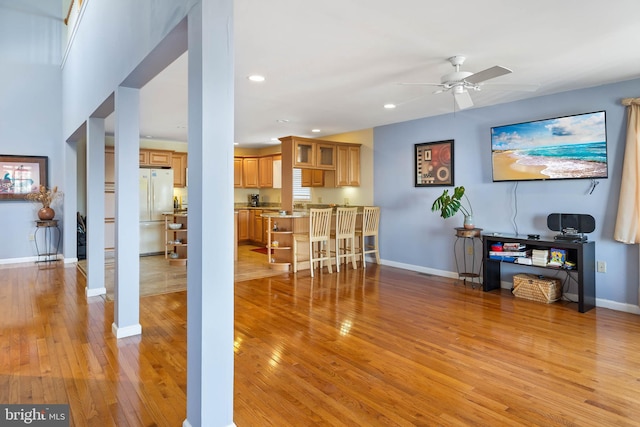 living room with ceiling fan and light hardwood / wood-style flooring