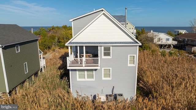 view of home's exterior with a water view and a balcony