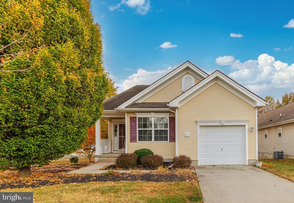 view of front of property featuring a garage, driveway, and central air condition unit