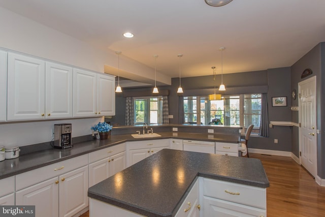 kitchen featuring a center island, kitchen peninsula, and white cabinets