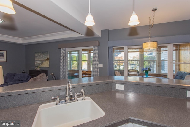 kitchen featuring sink, decorative light fixtures, crown molding, and a tray ceiling