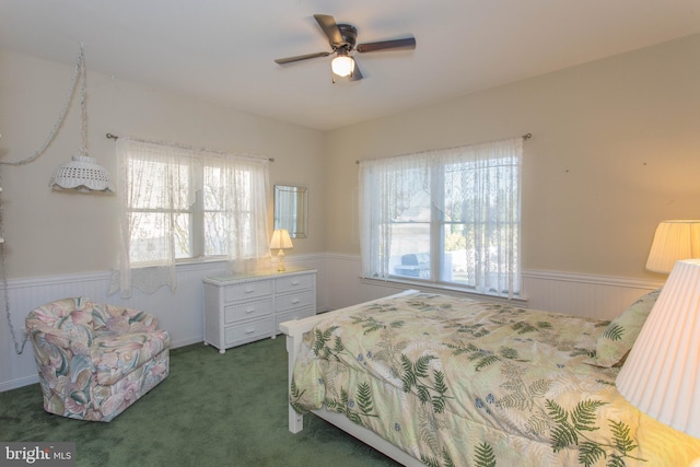 bedroom featuring multiple windows, ceiling fan, and dark carpet