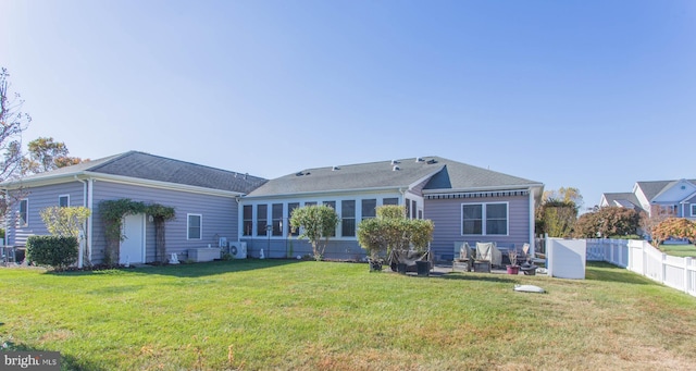 rear view of property with a sunroom and a yard