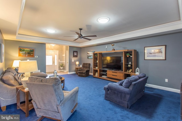 carpeted living room with a tray ceiling, ceiling fan, and crown molding