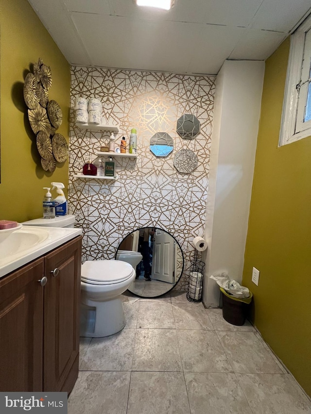 bathroom featuring tile patterned flooring, vanity, and toilet