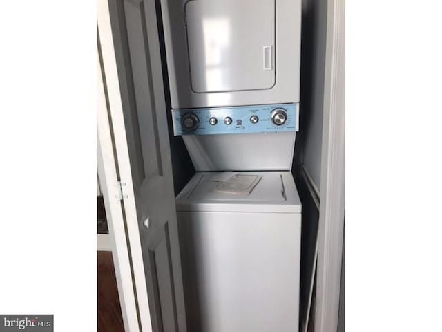 clothes washing area featuring stacked washer and dryer