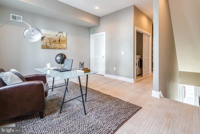 office with washer / dryer and light hardwood / wood-style flooring