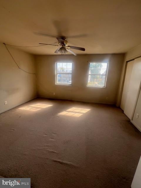 unfurnished room with ceiling fan and carpet