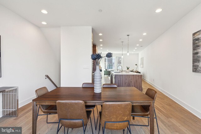 dining area with light wood-type flooring and sink