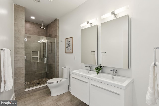 bathroom featuring vanity, toilet, and a shower with door