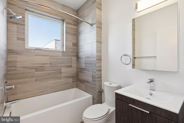 full bathroom with vanity, tiled shower / bath combo, and toilet