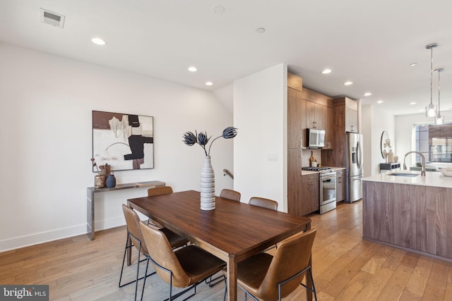 dining area with sink and light hardwood / wood-style flooring