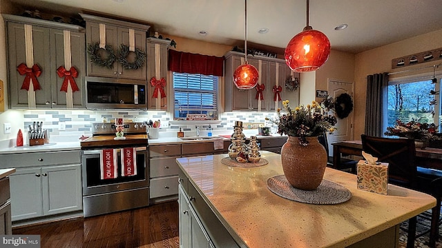 kitchen featuring stainless steel appliances, sink, pendant lighting, and backsplash