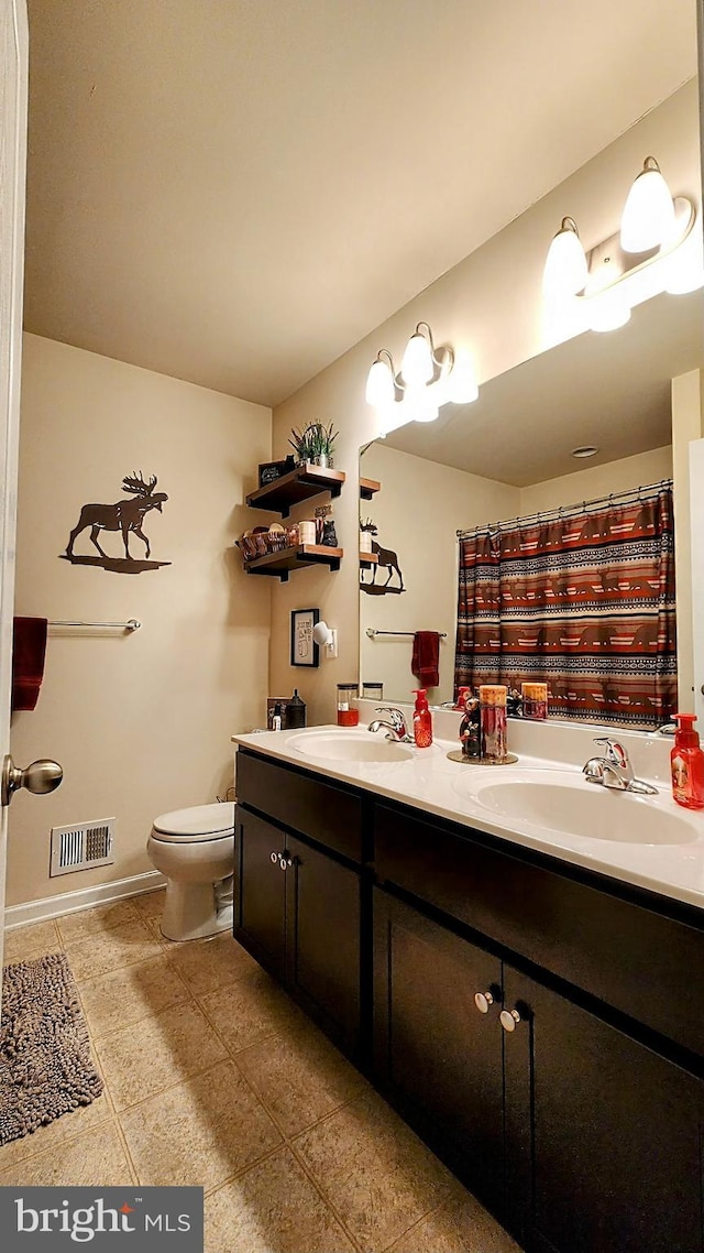 bathroom featuring vanity, curtained shower, and toilet