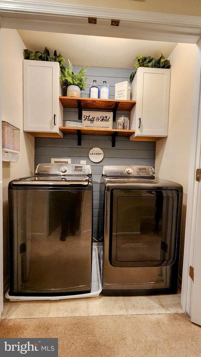 washroom with independent washer and dryer and cabinets