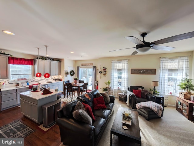 living room with dark hardwood / wood-style floors, a wealth of natural light, and ceiling fan