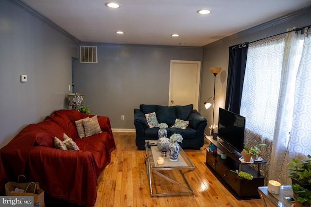 living area with ornamental molding, hardwood / wood-style floors, recessed lighting, and baseboards