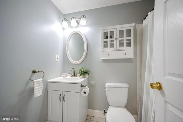 bathroom with toilet, vanity, tile patterned floors, and walk in shower