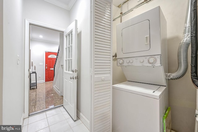 laundry room with stacked washer / dryer, ornamental molding, and light tile patterned flooring