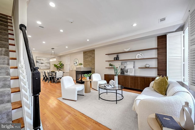 living room with light hardwood / wood-style floors and crown molding