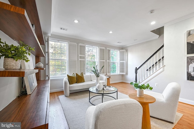 living room featuring hardwood / wood-style floors and crown molding