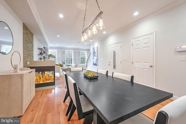 dining space with light wood-type flooring and ornamental molding